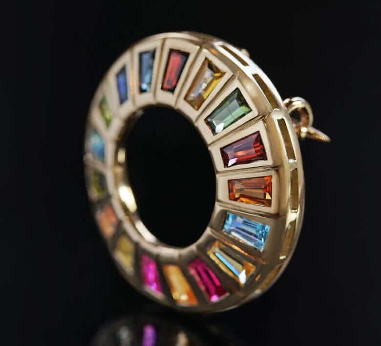 united nations inspired gemstone brooch