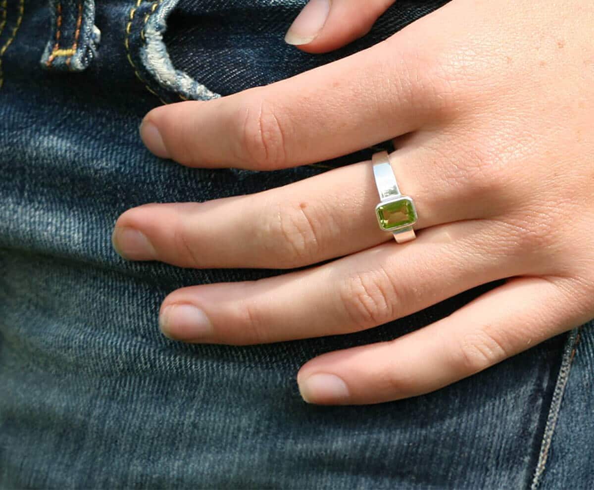 green dress ring on finger and jeans