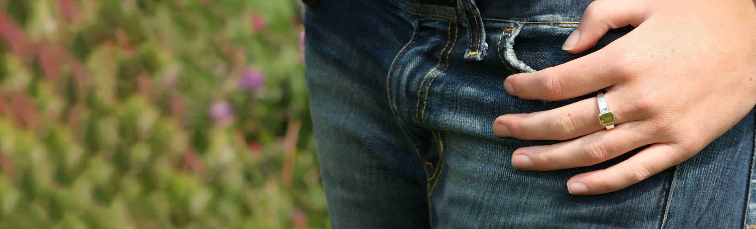 green dress ring on finger and jeans